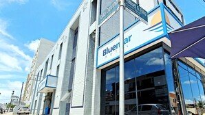 A building with a large glass facade and a sign for 'Bluecar Hotel'. - Bluemar Hotel (Maceió)