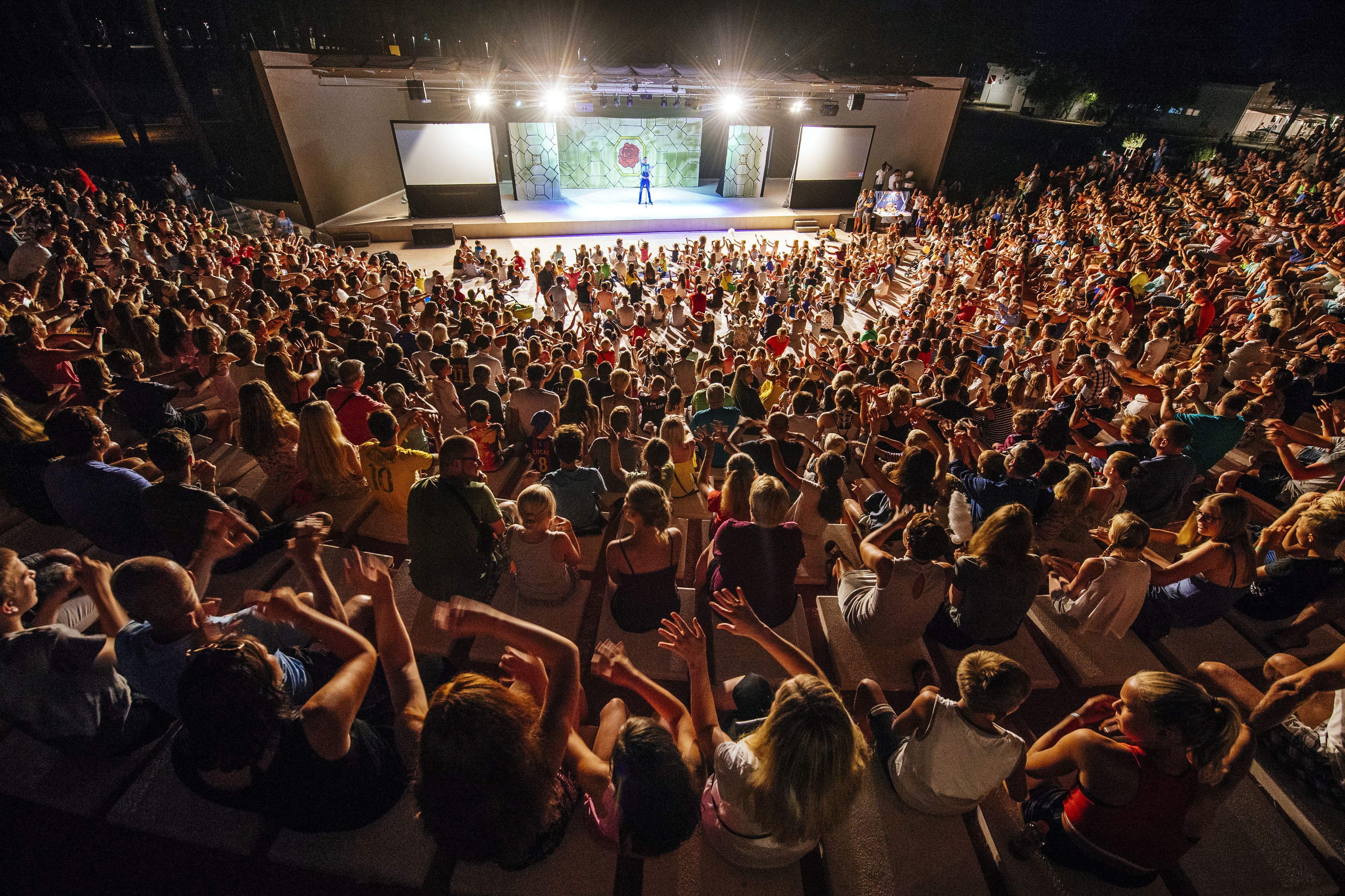A large indoor venue with a stage and a seated audience facing the stage.