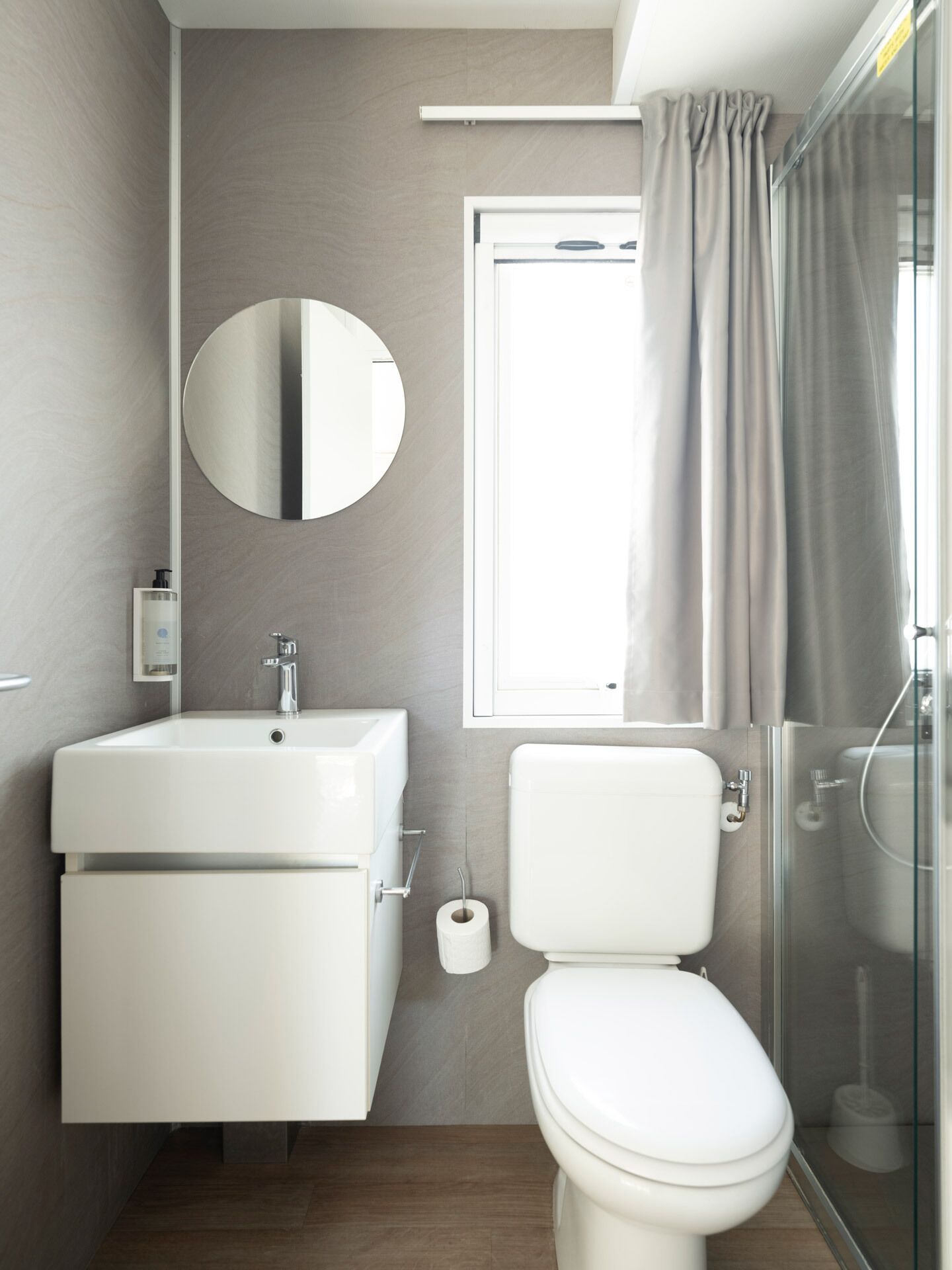 A modern bathroom with a sink, toilet, and shower.