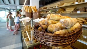 Una vitrina de panadería con panes y pasteles en cestas.