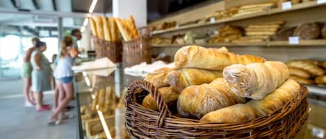 A bakery display with baskets of bread and pastries.