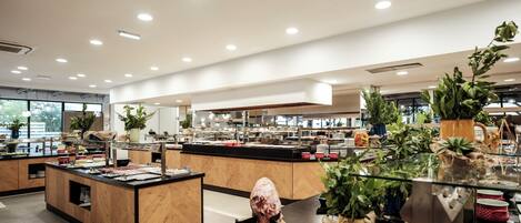 A modern buffet setup with various food items and plants.