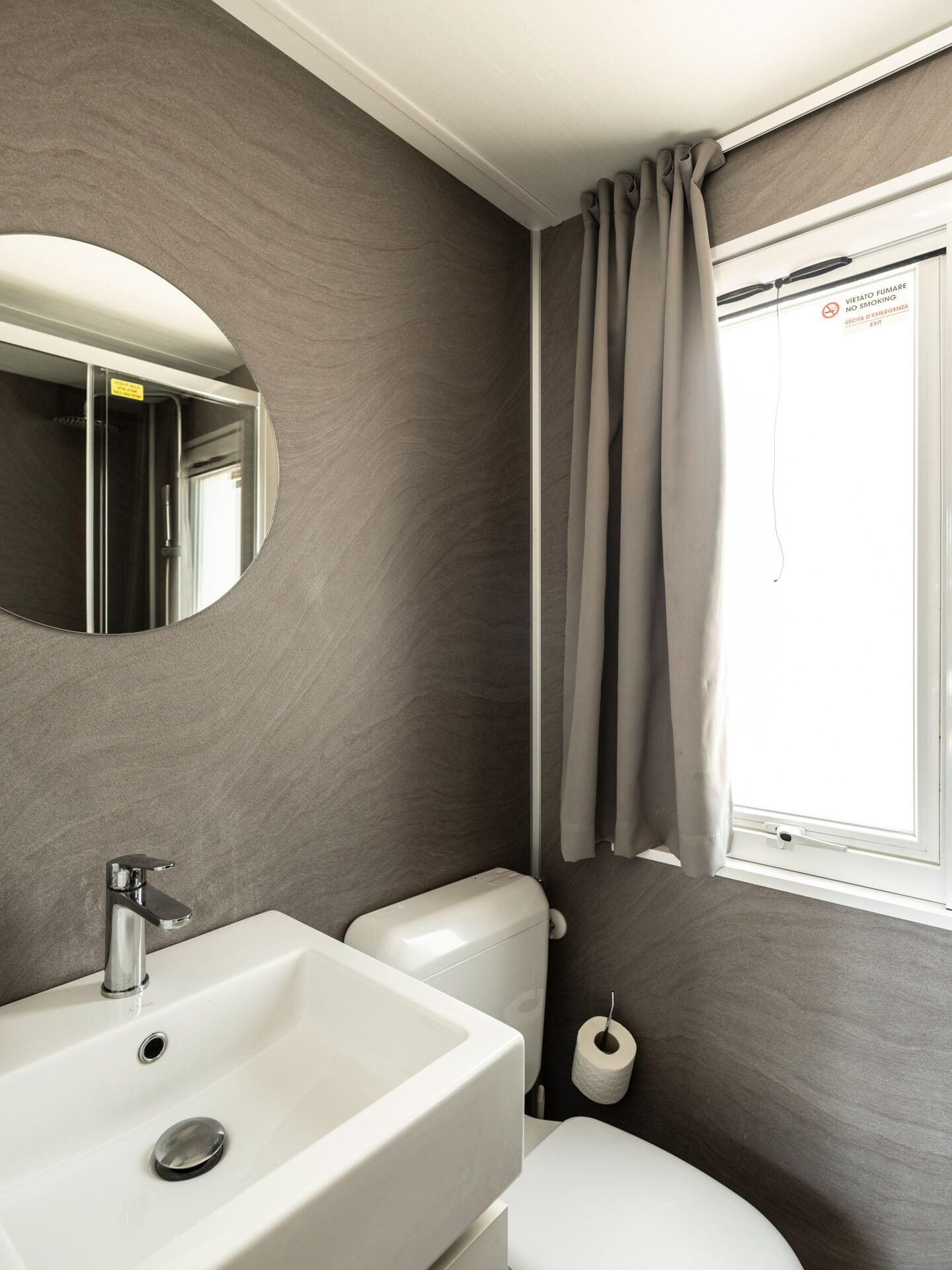 Une salle de bain avec un lavabo, des toilettes et un miroir.