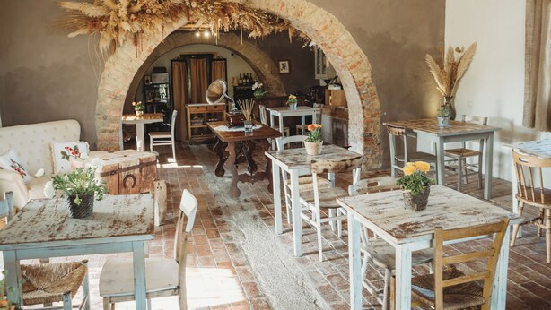 Un intérieur rustique avec des murs en briques apparentes, une arche en pierre et des meubles en bois.