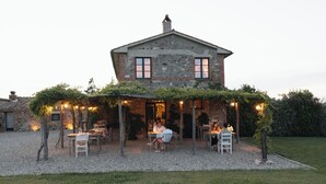 Il s’agit d’un bâtiment rustique en pierre, doté d’un patio couvert. Des tables et des chaises y sont disposées pour les repas.