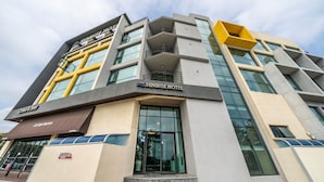 A modern hotel with a prominent 'Sunrise Hotel' sign, large windows, and a coffee shop named 'Coffee & Beer' on the ground floor. - Sunrise Hotel Jungmun (Seogwipo)