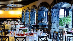 A restaurant with stone arches, white tablecloths, and neatly set dining tables. - Hotel Gradina Morii (Sighetu Marmatiei)