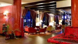 A lobby with red and black patterned sofas, a bar area, and a seating area with red chairs. - Hotel Gradina Morii (Sighetu Marmatiei)