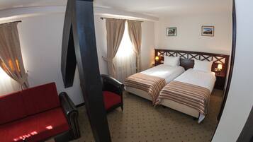 Una habitación de hotel con una cama, un sofá rojo y una silla.