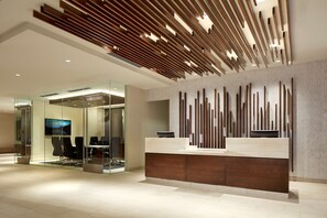 A modern reception area with a wooden slatted ceiling, a glass wall with a monitor, and a reception desk with a wooden finish. - Homewood Suites by Hilton San Diego Mission Valley/Zoo (San Diego)