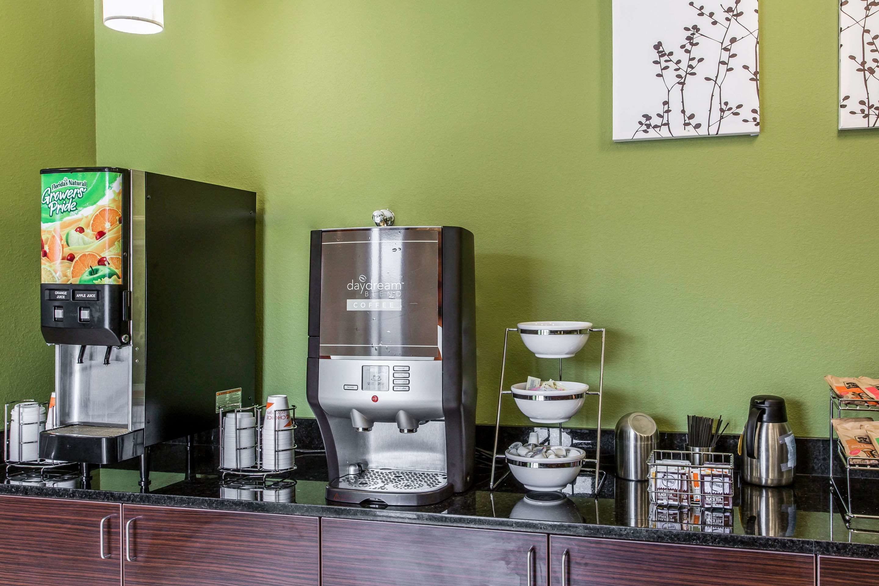 Una estación de café con dos máquinas de café, un dispensador de bebidas y una exhibición de granos de café.
