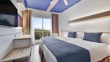 Ein modernes Hotelzimmer mit einem großen Bett, einem Schreibtisch und einem Balkon mit Blick.