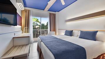 Quarto de hotel moderno com uma cama grande, uma escrivaninha e um ventilador de teto.