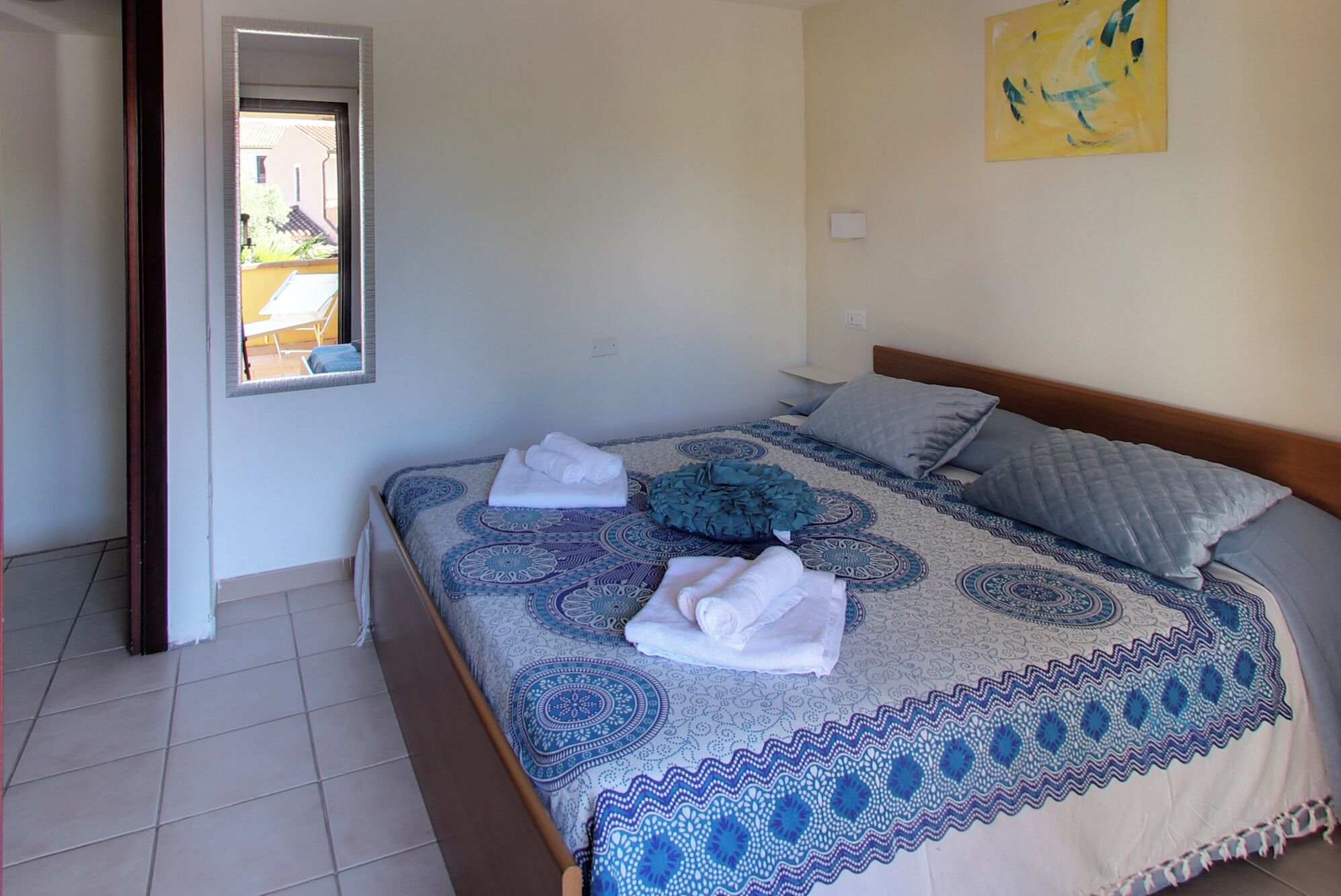 A bedroom with a bed, pillows, and a window.