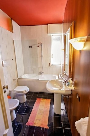 A bathroom with a bathtub, two sinks, and a shower. - L'Attico di Sara (Lecce)