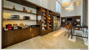 A modern kitchen with a coffee machine, toaster, and shelves stocked with snacks and beverages. - Linx Confins by Wish (Confins)