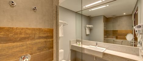 A modern bathroom with a shower, toilet, and sink.