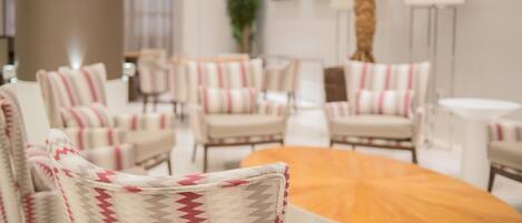 A modern indoor seating area with patterned chairs and a central round table.