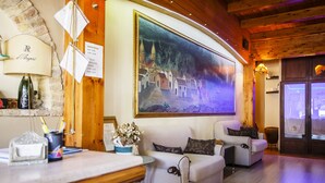 Un área de recepción con un cuadro grande, una mesa de recepción, un sofá y un techo de madera.