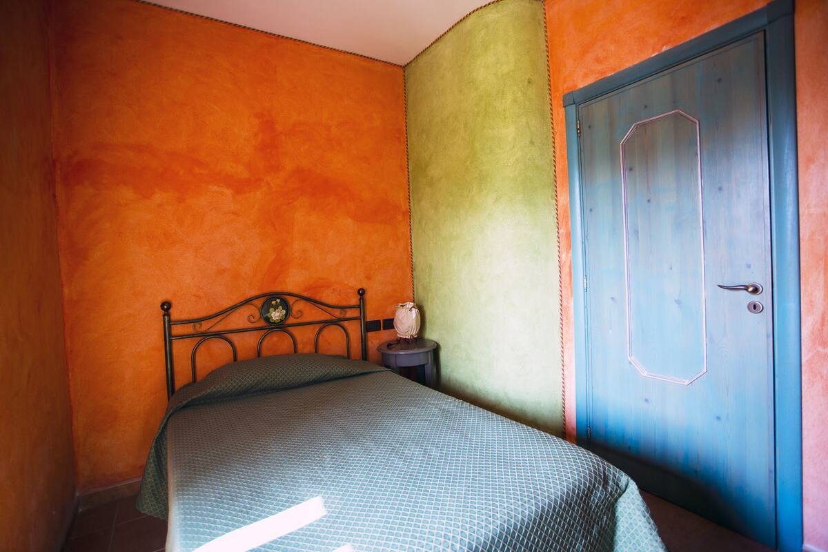 Una habitación con una cama, una mesita de noche y una puerta.