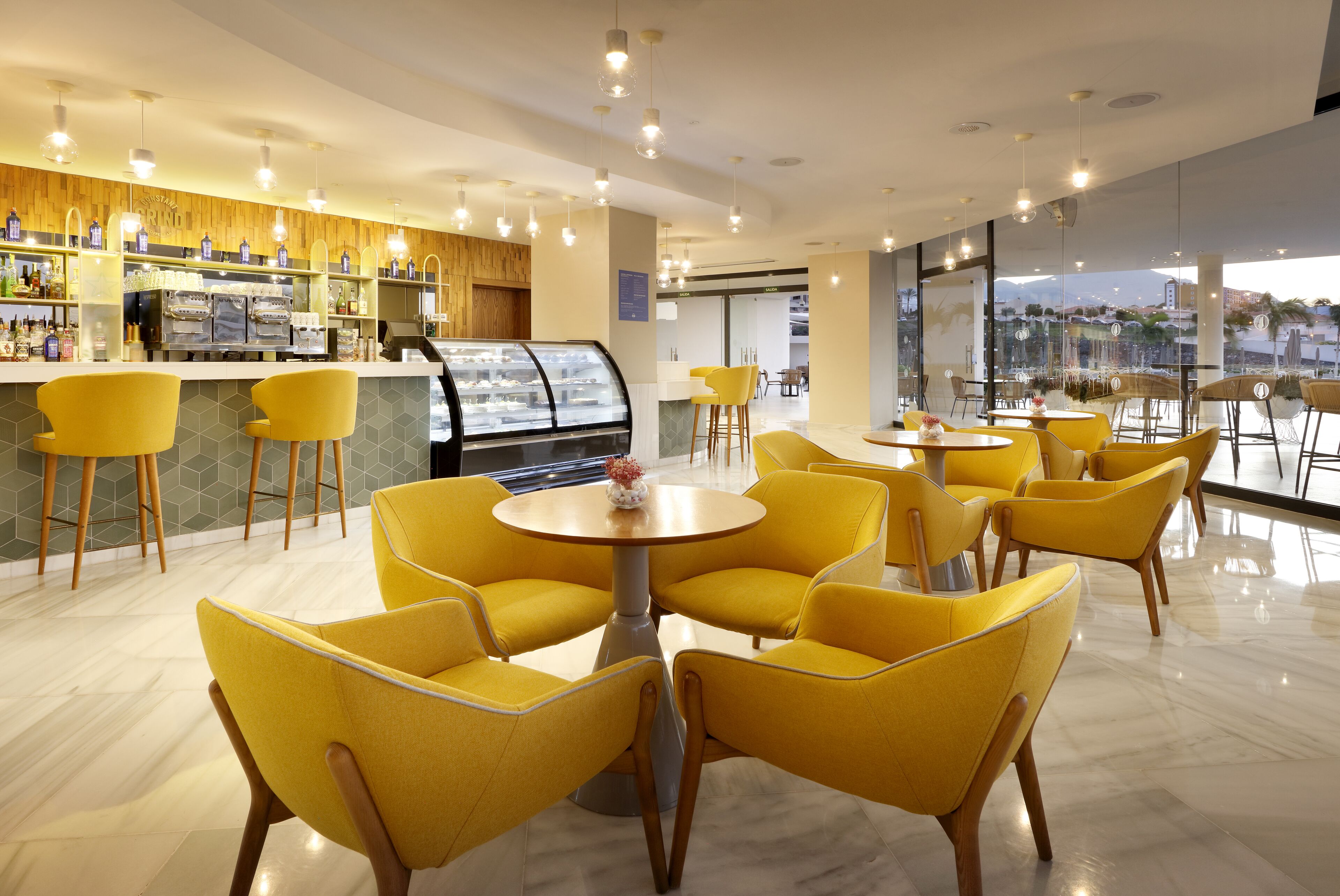 Un café moderno con sillas amarillas y una barra de café.