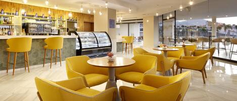 A modern cafe with yellow chairs and a coffee bar.
