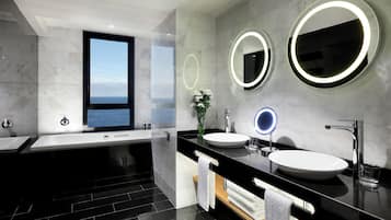 Une salle de bain moderne avec deux lavabos, un grand miroir et une baignoire.