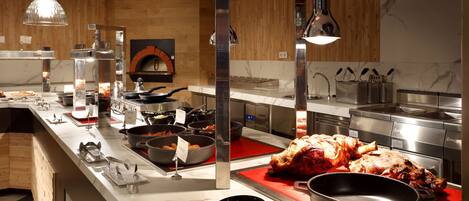 A buffet setup with various food items and cooking equipment.