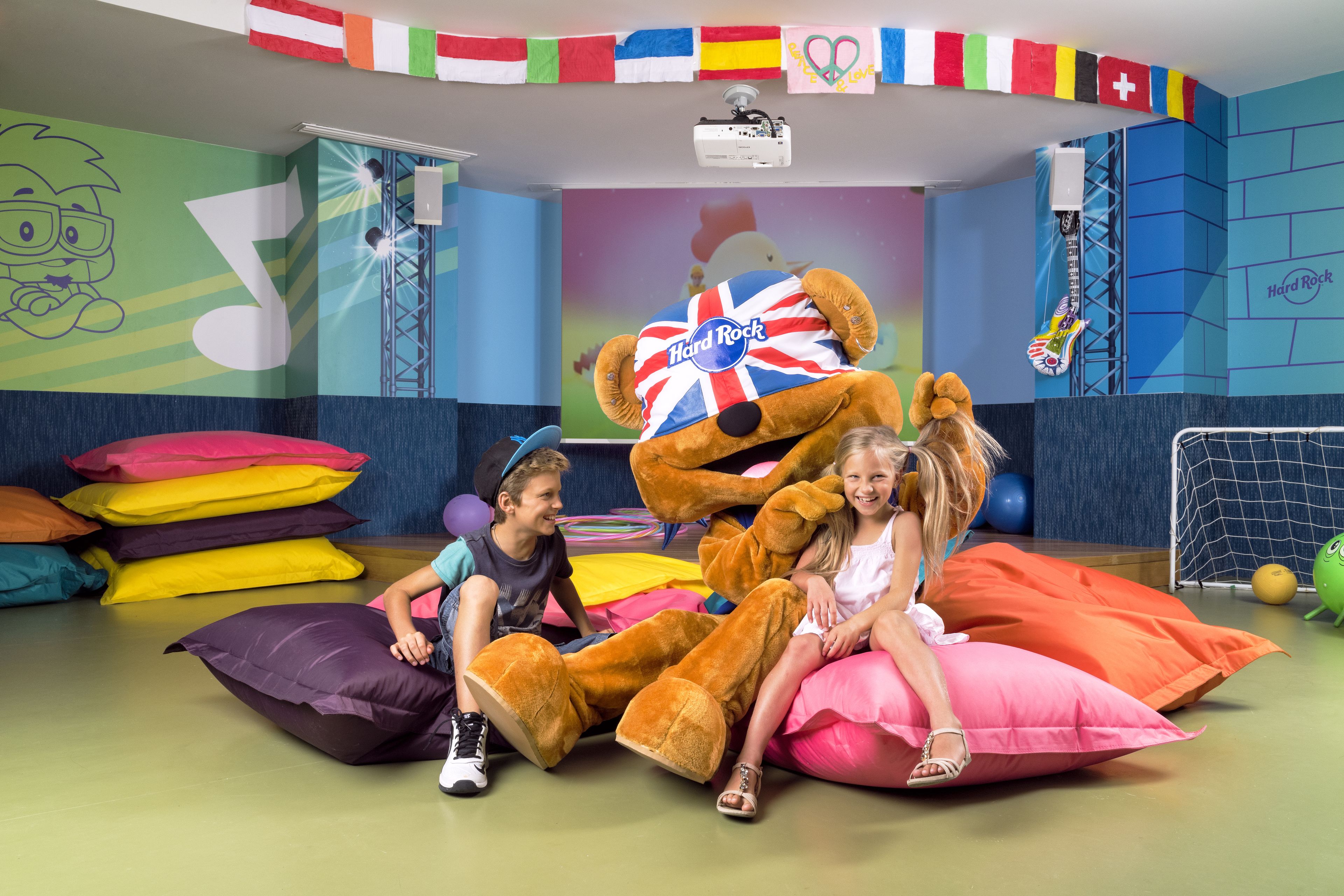 A room with a large mascot, colorful pillows, and a Hard Rock-themed wall.