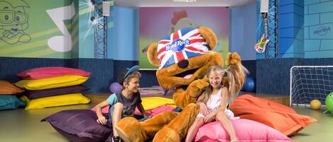 A room with a large mascot, colorful pillows, and a Hard Rock-themed wall.