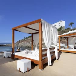 On the beach, black sand, sun loungers, beach umbrellas