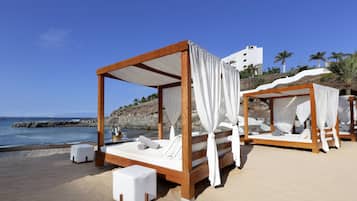 Ubicación a pie de playa, arena negra, tumbonas y sombrillas