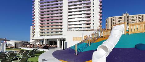 A modern hotel with a colorful play area and outdoor seating.