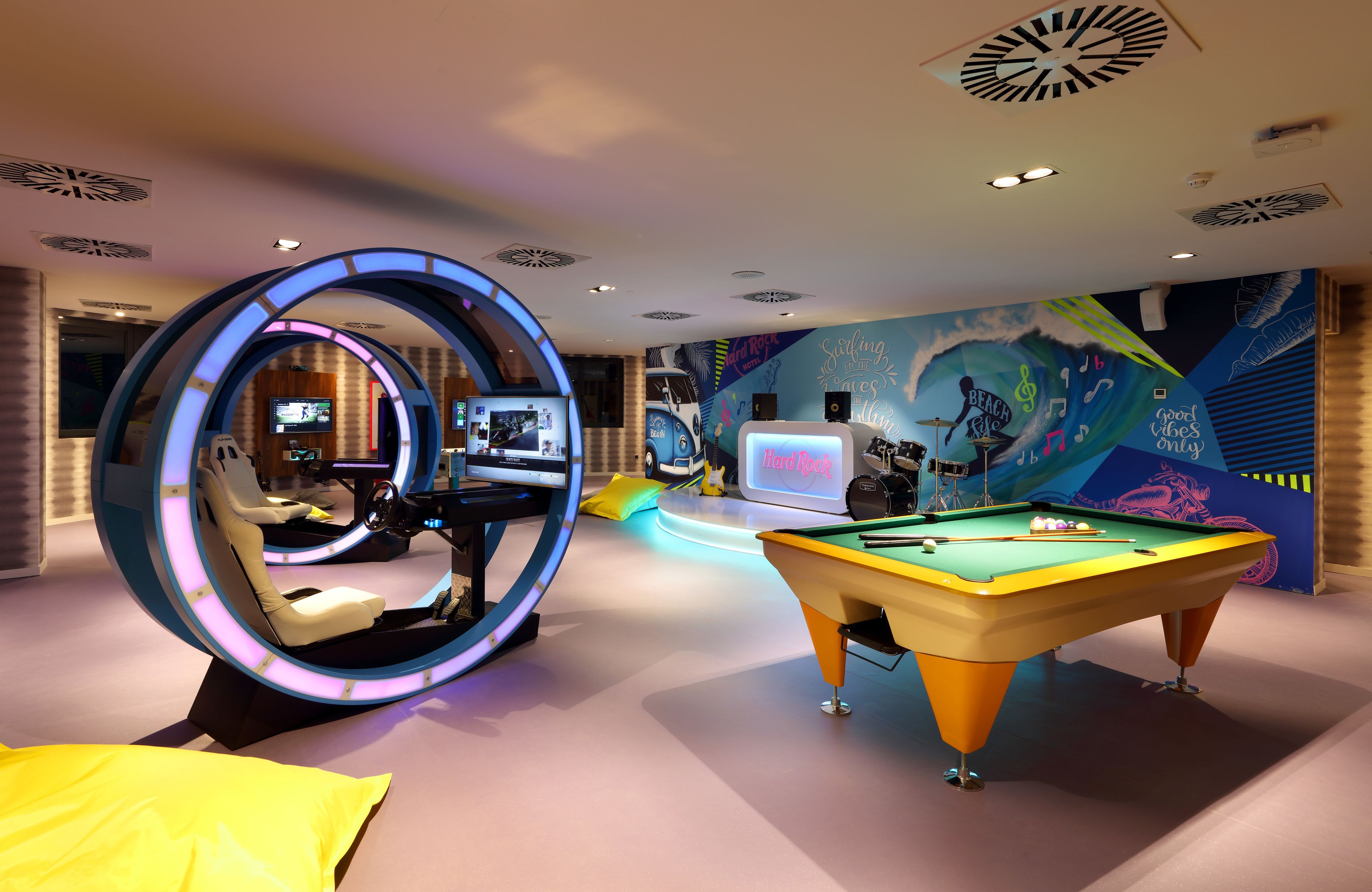 A pool table, a massage chair, and a wall with a mural.