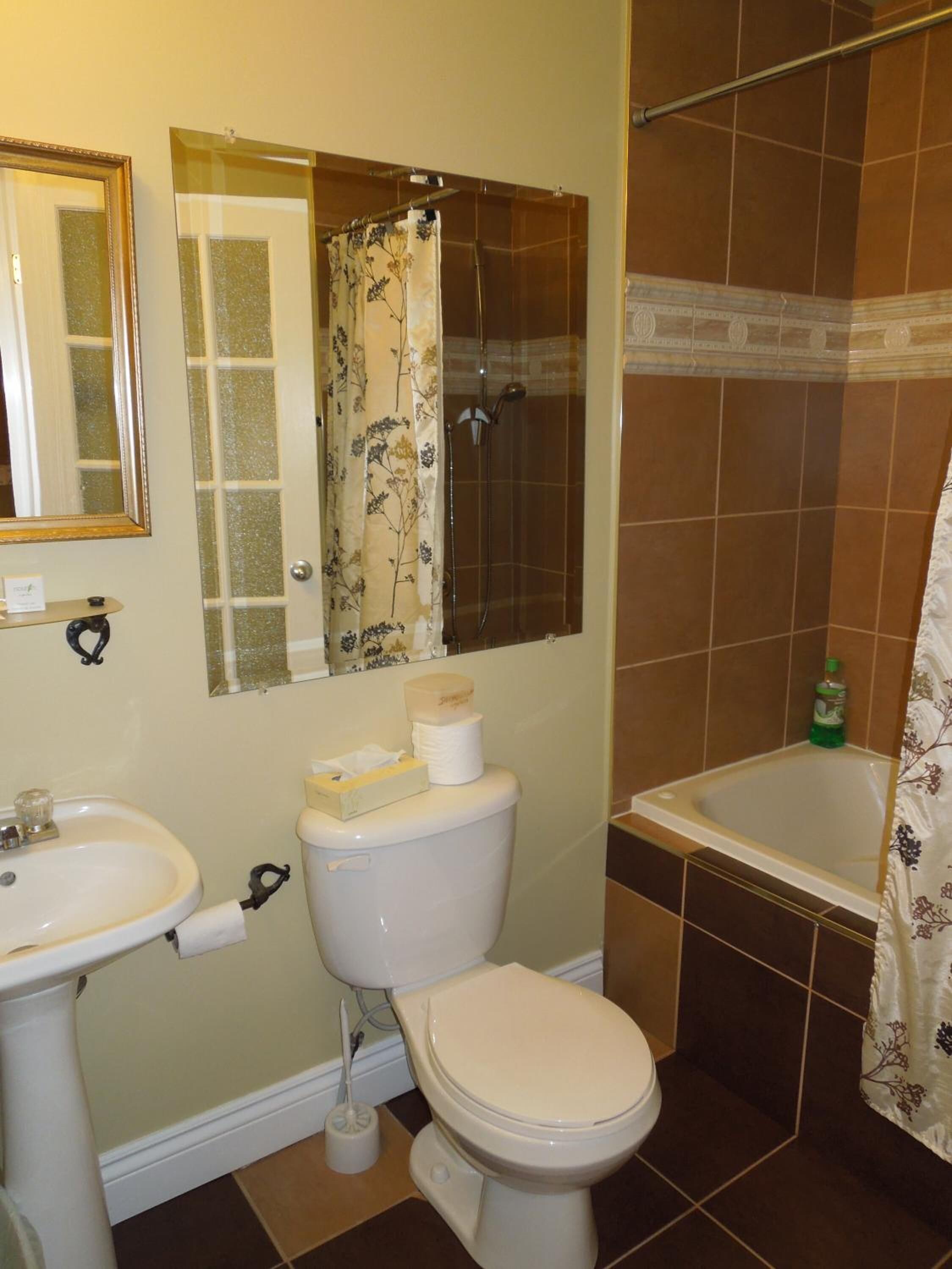 A bathroom with a toilet, sink, shower, and bathtub.