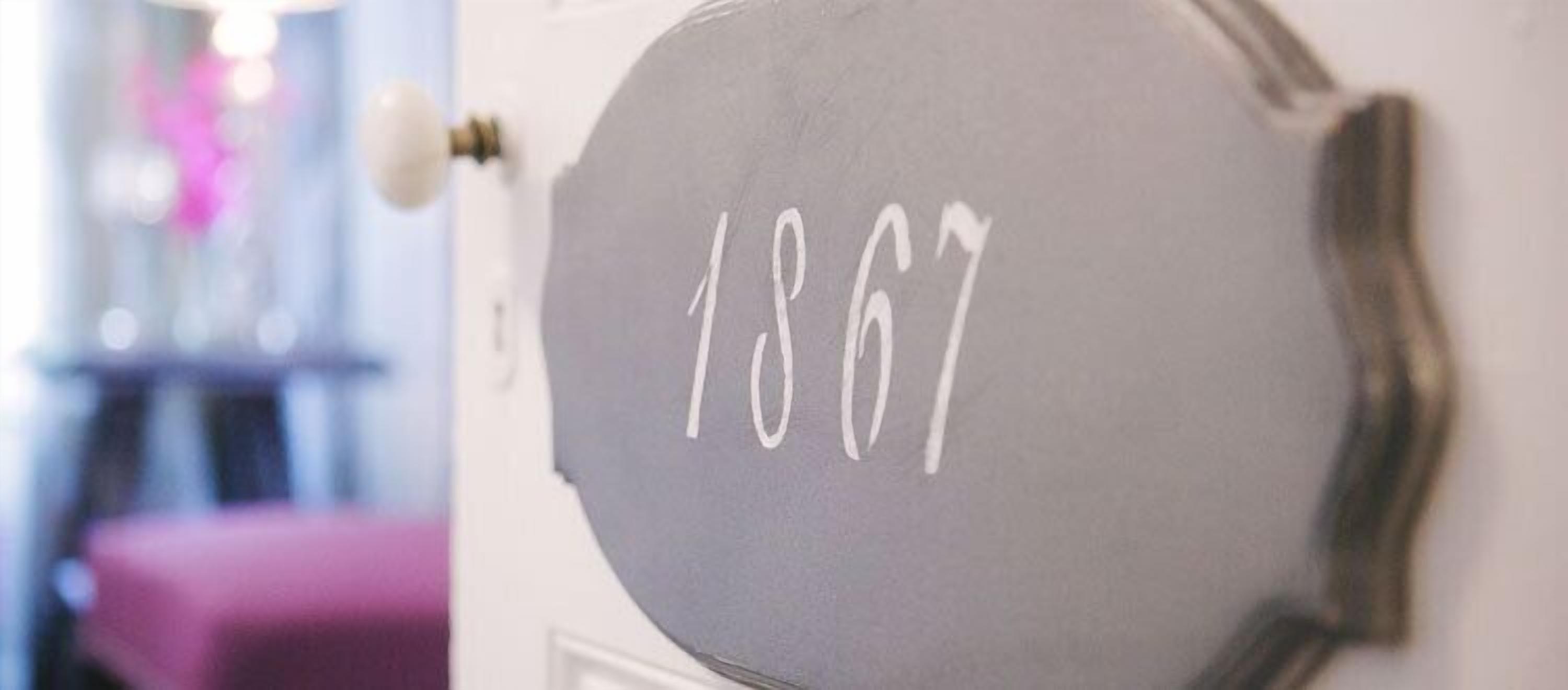 Une porte sur laquelle est peint le numéro 1867.