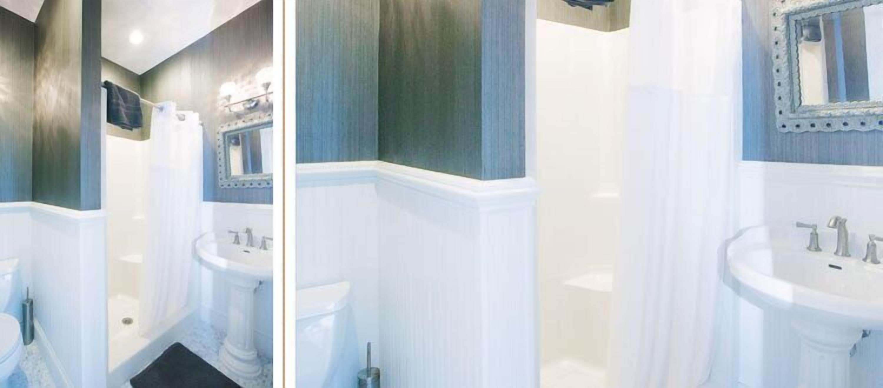 A bathroom with a pedestal sink, a bathtub, and a mirror with a decorative frame.
