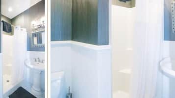 A bathroom with a pedestal sink, a bathtub, and a mirror with a decorative frame.