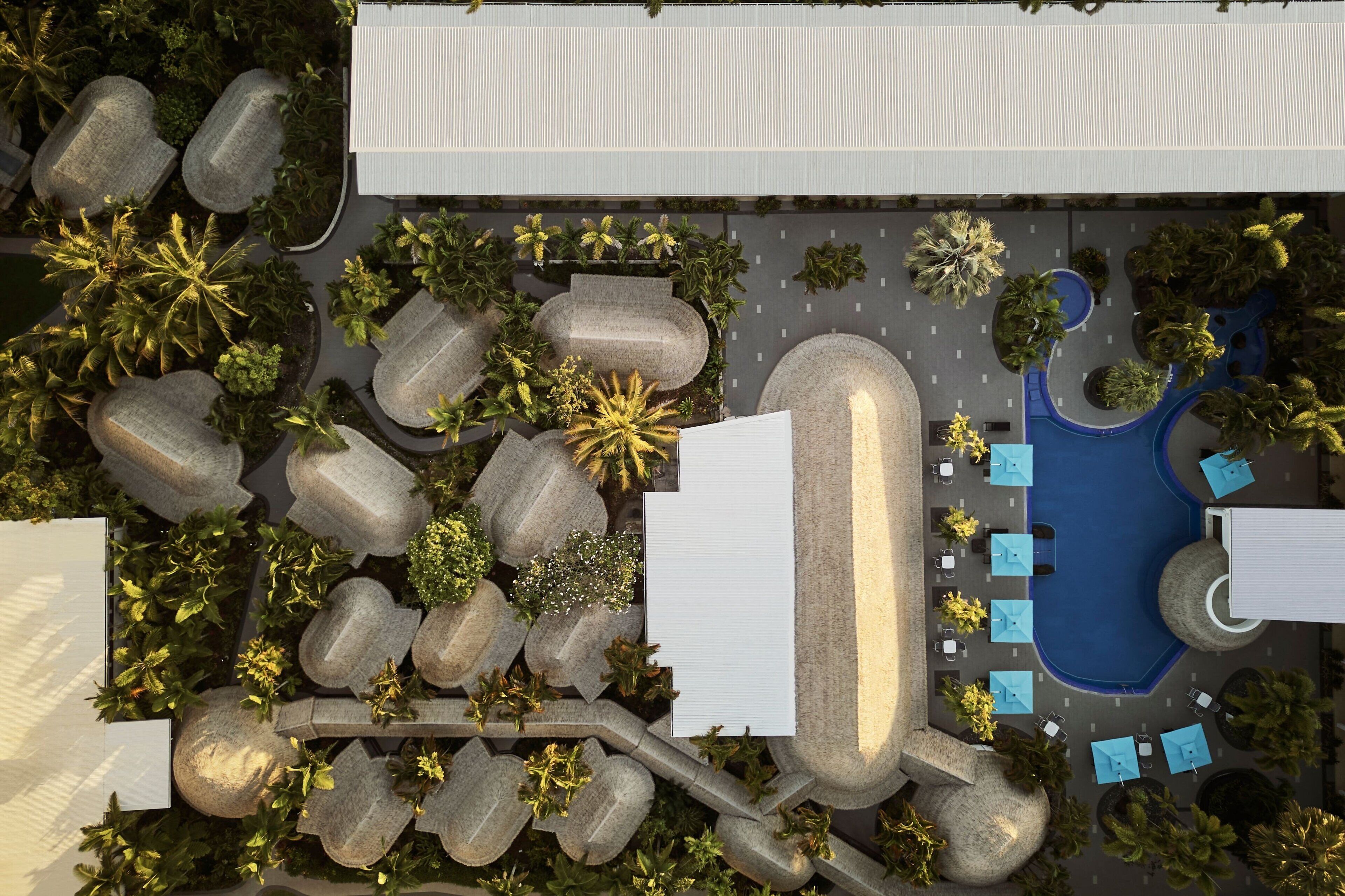 Vista aérea de un hotel con piscina, zonas de estar al aire libre y jardines ajardinados.