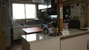 Una zona de cocina con una caja registradora, una cafetera y un letrero que indica la presencia de un cajero.