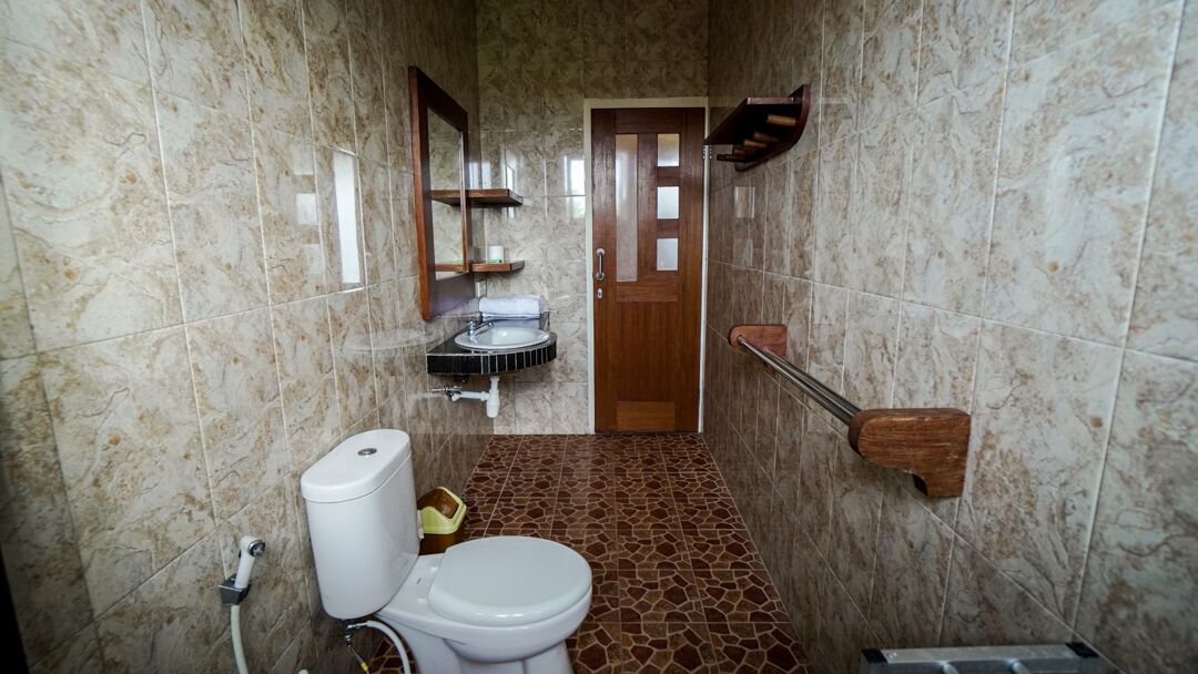 A bathroom with a toilet, sink, and mirror.