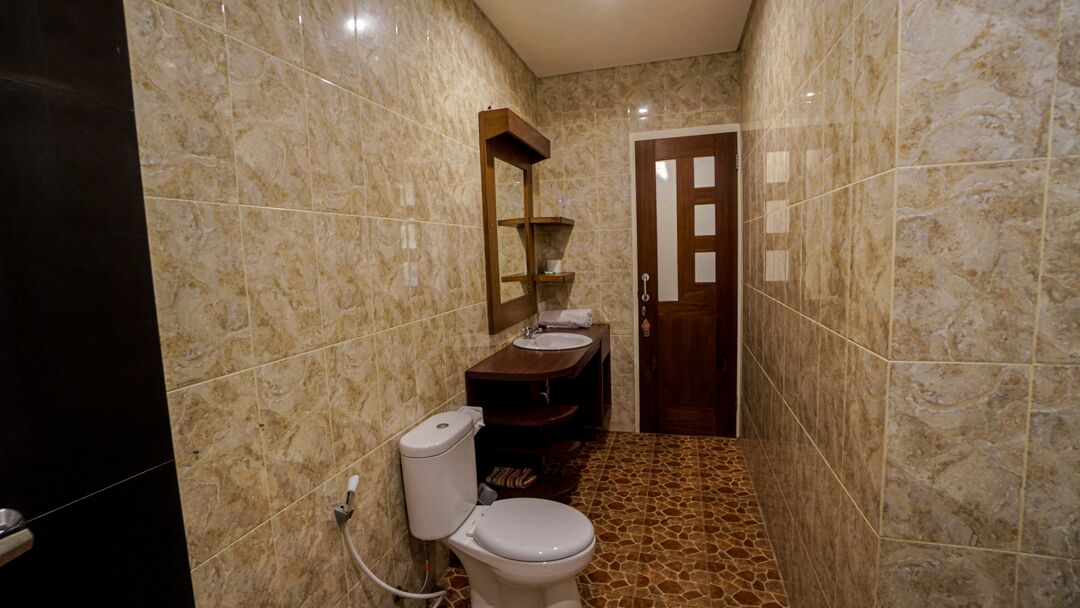 A bathroom with a toilet, sink, and mirror.