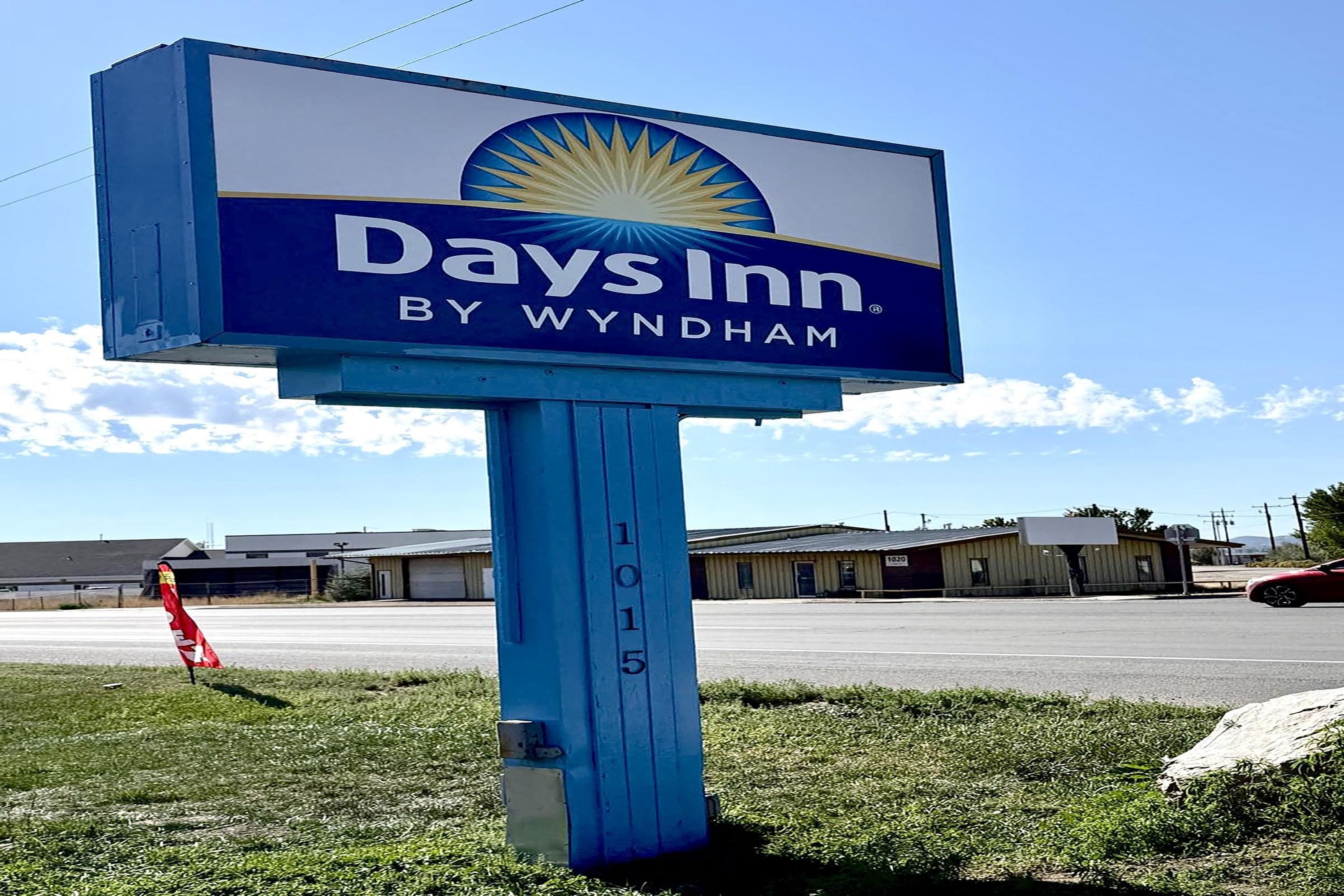 Days Inn -kyltti, jossa on aurinkokuva ja teksti ”Days Inn by Wyndham” sinisellä pohjalla.