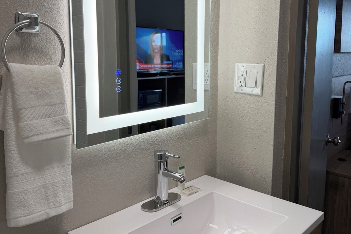 Une salle de bain avec un lavabo blanc, un miroir et un porte-serviettes.