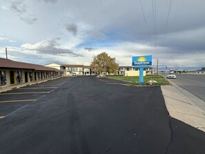 Un Days Inn by Wyndham con estacionamiento, edificios tipo motel y cielo despejado.