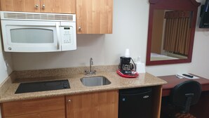 A compact kitchen with a microwave, sink, coffee maker, and a small refrigerator. - Split Mountain Motel (Vernal)