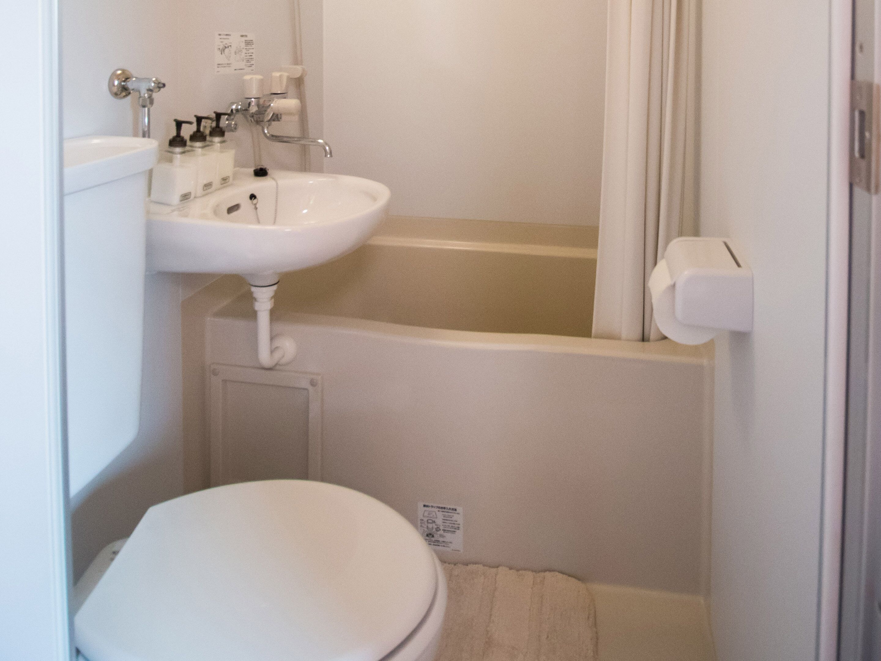 A small bathroom with a white toilet, a sink, and a bathtub.