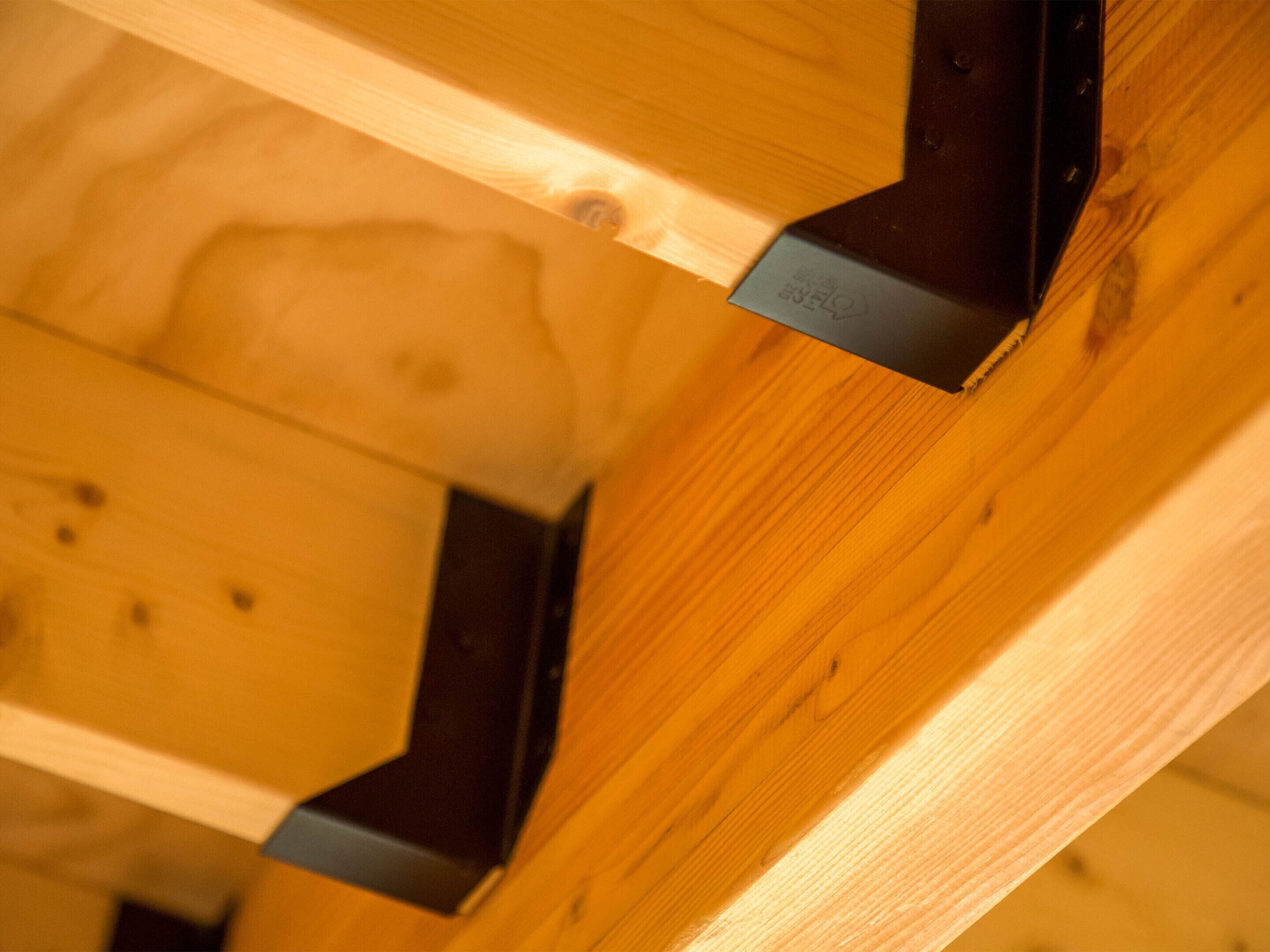 A close-up of a wooden structure with metal brackets.