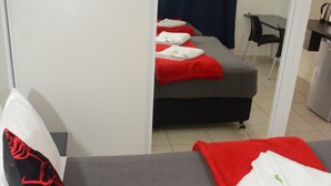 A hotel room with a bed, a desk, and a chair. - Capricorn Hotel (Blackwater)