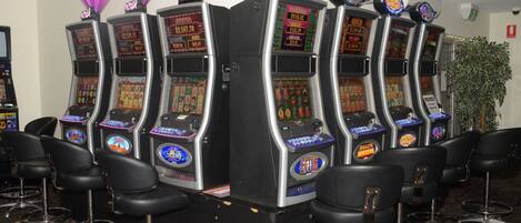 A row of slot machines with a plant in the background.